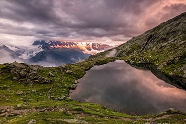 Clouds are tinged with purple at sunset at Lac de Cheserys, Chamonix, Haute Savoie, French Alps, France, Europe