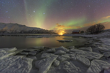 The Northern Lights illuminates the icy landscape in Svensby, Lyngen Alps, Troms, Lapland, Norway, Scandinavia, Europe