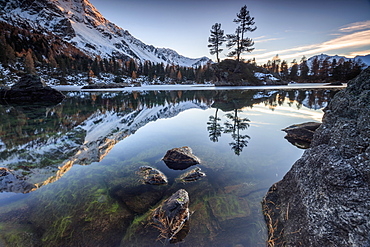 Autumn reflections at Saoseo Lake still partially frozen, Poschiavo Valley, Canton of Graubuenden, Switzerland, Europe