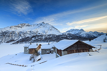 Huts and mountains covered in snow at sunset, Spluga Maloja, Canton of Graubunden, Engadine, Switzerland, Europe