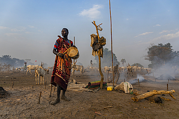 Mundari man drumming to call back the cows, Mundari tribe, South Sudan, Africa