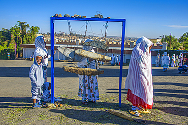 Pilgrims at an old stone bell at the Coptic Cathedral of St. Mariam, Asmara, Eritrea, Africa