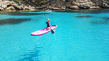 Aerial of a young girl paddling on a SUP on the Formentor Peninsula, Mallorca, Balearic islands, Spain, Mediterranean, Europe