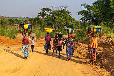 Women carrying goods and water on their heads on the very bad road between Tshikapa and Kananga, Kasai, Democratic Republic of Congo, Africa