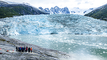 Tourists standing below Pia glacier, Tierra del Fuego, Chile, South America