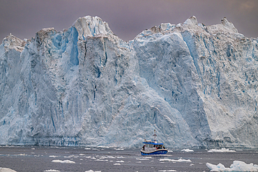 Little boat between the icebergs of the Ilulissat Icefjord, UNESCO World Heritage Site, Western Greenland, Denmark, Polar Regions