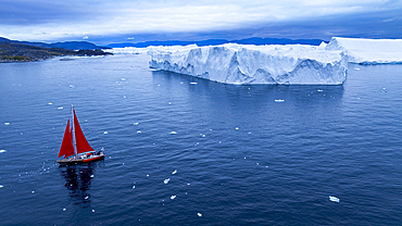 Aerial of a red sailing boat in the Ilulissat Icefjord, UNESCO World Heritage Site, Western Greenland, Denmark, Polar Regions