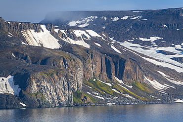 Green cliff in the glacier covered mountains of Franz Josef Land archipelago, Arkhangelsk Oblast, Arctic, Russia, Europe