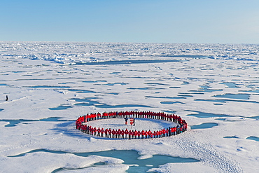 People wearing red forming circle around North Pole, Arctic