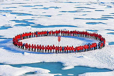 People wearing red forming circle around North Pole, Arctic