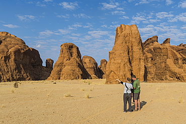 Couple looking at beautiful rock formations, Ennedi Plateau, UNESCO World Heritage Site, Ennedi region, Chad, Africa