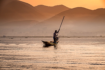 Young fisherman with net at sunrise, Inle Lake, Shan state, Myanmar (Burma), Asia