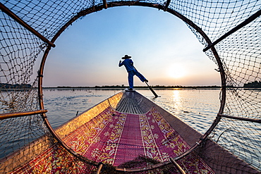 Fisherman at Inle Lake with traditional Intha conical net at sunset, fishing net, leg rowing style, Intha people, Inle Lake, Shan state, Myanmar (Burma), Asia