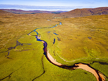 Aerial of a river snaking through the moor of the Black Cuillin ridge, Isle of Skye, Inner Hebrides, Scotland, United Kingdom, Europe