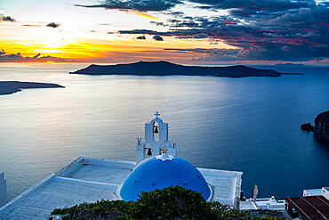 Sunset over the volcanic islands of Santorini and Anastasi Orthodox Church at sunset, Fira, Santorini, Cyclades, Greek Islands, Greece, Europe