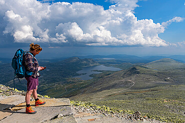 Hiker looking at the scenery around Gausta (Gaustatoppen), highest mountain in Norway, Telemark, Norway, Scandinavia, Europe