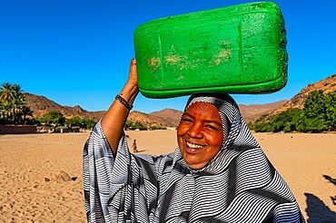 Woman carrying a water container on her head, Oasis of Timia, Air Mountains, Niger, Africa