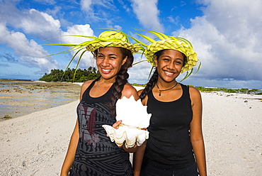 Local girls with palm leaves hats posing in the lagoon of Wallis, Wallis and Futuna, Pacific