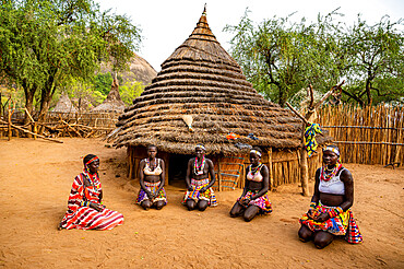 Young women in front of a traditional village hut of the Laarim tribe, Boya Hills, Eastern Equatoria, South Sudan, Africa