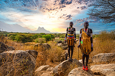 Traditional dressed young girls from the Laarim tribe standing on a rock, Boya Hills, Eastern Equatoria, South Sudan, Africa