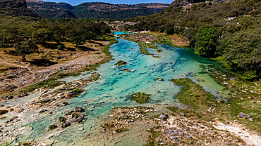 Aerial of a turquoise river in Wadi Darbat, Salalah, Oman, Middle East