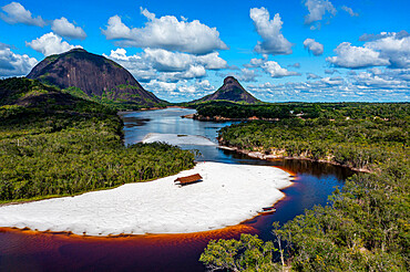 Black river and white sand beach in front of granite hills, Cerros de Mavecure, Eastern Colombia, South America