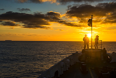 Tourists standing on the bow of a cruise ship watching the sunset, South Orkney Islands, Antarctica, Polar Regions