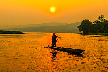 Man on his dugout canoe at sunset on the Congo River, Democratic Republic of the Congo, Africa