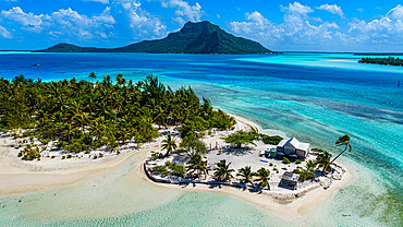 Aerial of a little islet with a white sand beach and the lagoon of Maupiti, Society Islands, French Polynesia, South Pacific, Pacific