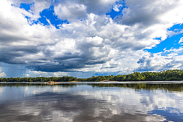 Reflections of clouds in the Casiquiare River in the deep south of Venezuela, South America