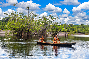 Father and son from the Yanomami tribe in a canoe, southern Venezuela, South America