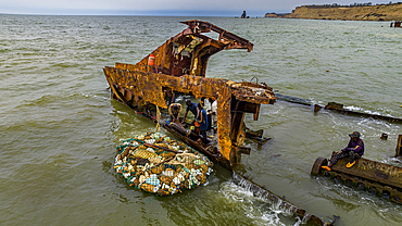 Men dismantling a boat on Shipwreck beach, Bay of Santiago, Luanda, Angola, Africa