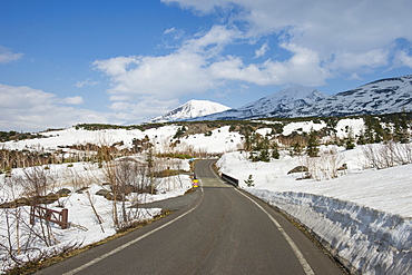 Road leading through the snow capped mountains of the Daisetsuzan National Park, UNESCO World Heritage Site, Hokkaido, Japan, Asia