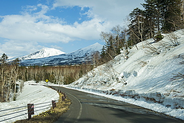 Road leading through the snow capped mountains of the Daisetsuzan National Park, UNESCO World Heritage Site, Hokkaido, Japan, Asia