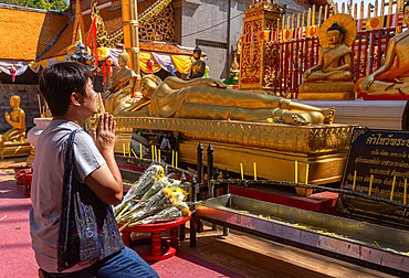 View and visitors and tourists praying at the Wat Suthep historical Buddhist temple in the forest above Chiang Mai, Thailand