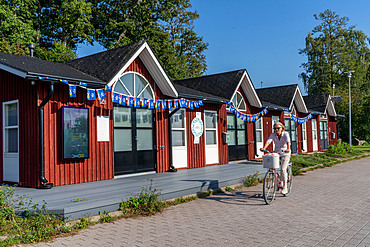 Woman cycling near sailing marina and beaches in Matinkylan, near Espoo, Finland, Europe