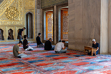 Visitors praying at the Blue Mosque in Istanbul, Turkey, Türkiye