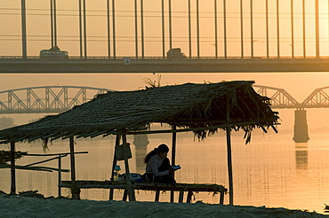 Myanmar (burma) sunset at mandalay harbour with bridges on background on the irrawady river near sagaing