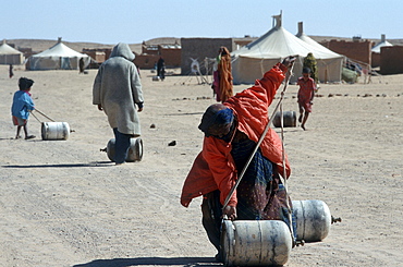 Western sahara. Women and children carrying gas bottles. Polisario smara camp.