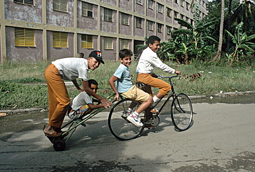 Cuba children on a long bycicle havana