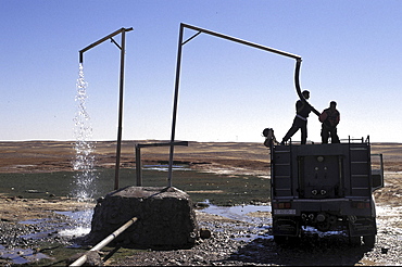 Refugee camp, algeria. Lorries loading water from main pipe at polisario central camp