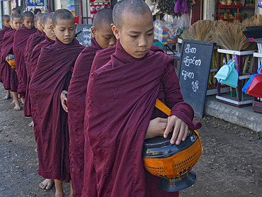 Young monks receiving food gifts in Bagan, Myanmar (Burma), Asia