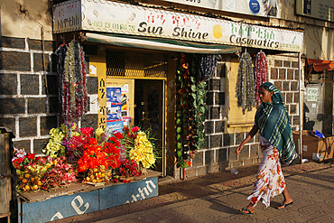 Woman in traditional dress walks in a shopping street in Bahir Dar, Ethiopia, Africa