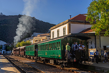 Visitors on a steam train to the Port wine vineyards and wineries in the Douro valley region in Pinhao,Porto,Portugal