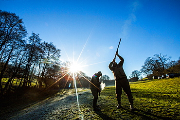 Game-shooters on a blue sky day with sun star, Norfolk, England, United Kingdom, Europe