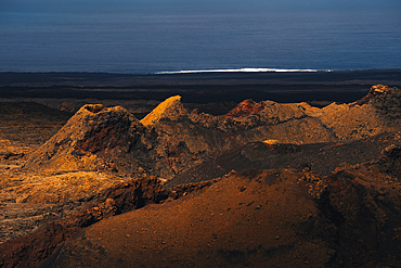 view of Volcanoes and the Volcanic landscape with the Atlantic Ocean in the Timanfaya national park in Lanzarote in the Canary Islands, Spain