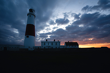 Portland Bill Lighthouse with sunset behind, Portland, Dorset, UK