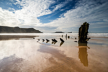 Helvetia shipwreck and clouds reflected in wet sand, at low tide, Rhossili Bay, Gower Peninsula, South Wales, United Kingdom, Europe