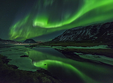 Aurora borealis (Northern Lights) reflected in partially frozen lake, North Snaefellsnes, Iceland, Polar Regions