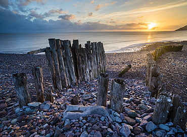 Remains of a wooden groyne at Porlock Weir, sunrise in spring, Somerset, England, United Kingdom, Europe